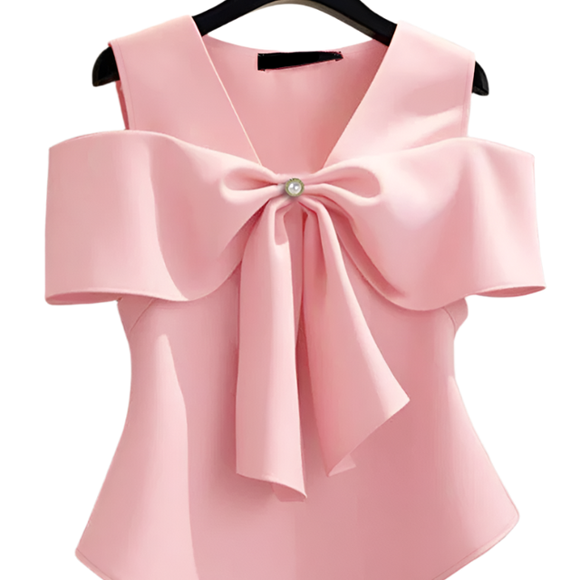 Pink blouse with a large bow on a hanger against a neutral background
