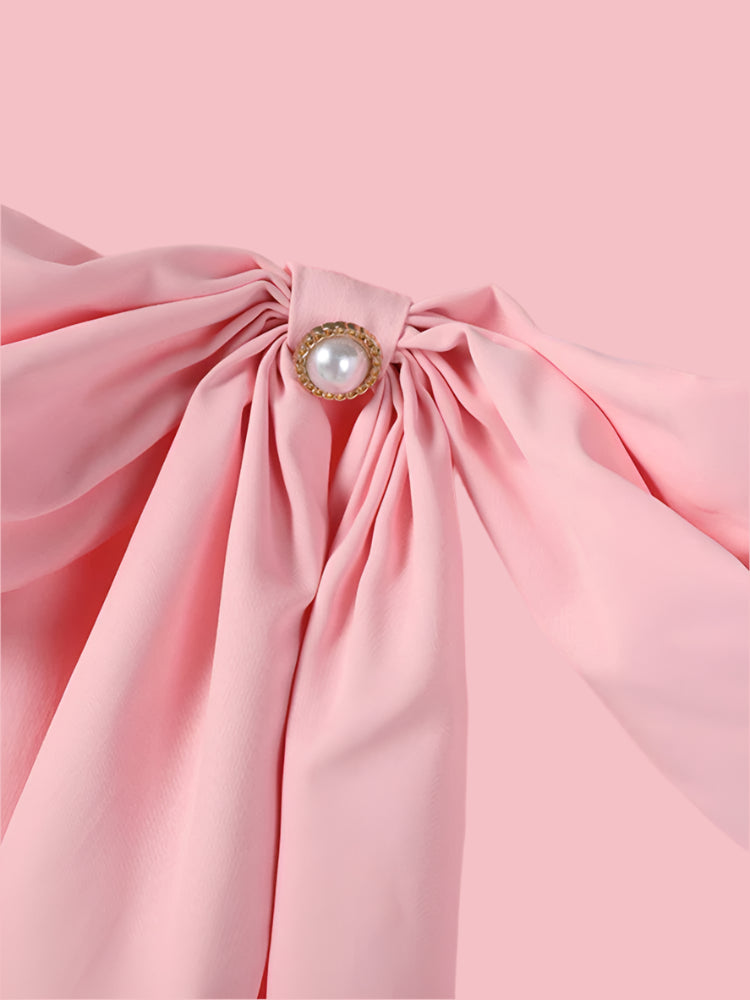 Close-up of a pink dress with a bow and pearl detail, brand 'ZANZEA' visible.