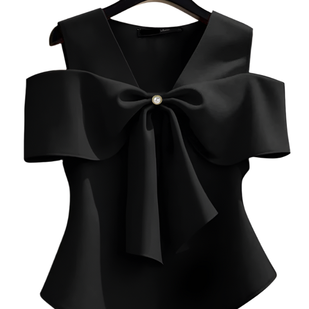 Black blouse with a large bow on a hanger against a neutral background