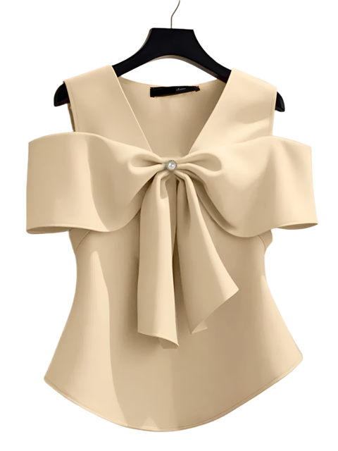 Beige blouse with a large bow detail on a hanger against a neutral background