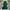 Green dress with ruffled sleeves and bottom on a gray surface with decorative elements.