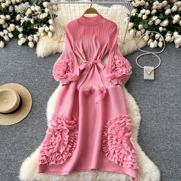 Pink dress with floral details on a gray surface with decorative elements.