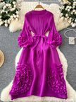 Purple dress with floral details on a hanger against a decorative background