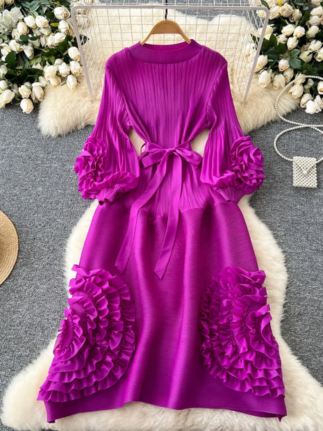 Purple dress with floral details on a hanger against a decorative background