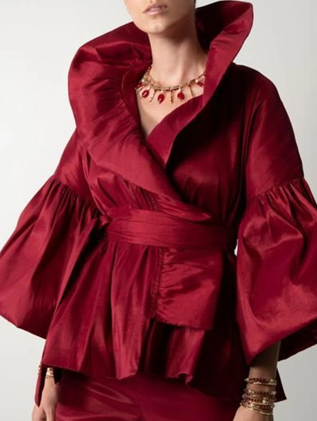 Red dress with puffed sleeves and a belt on a plain background