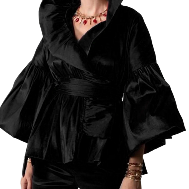 Black ruffled top worn by a person on a plain background