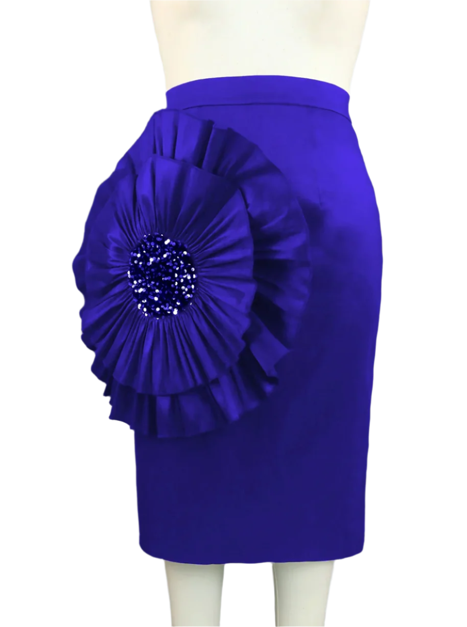 Blue skirt with a large floral embellishment on a mannequin against a gray curtain background