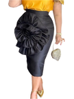 Person wearing a black skirt with a large floral embellishment, standing indoors.