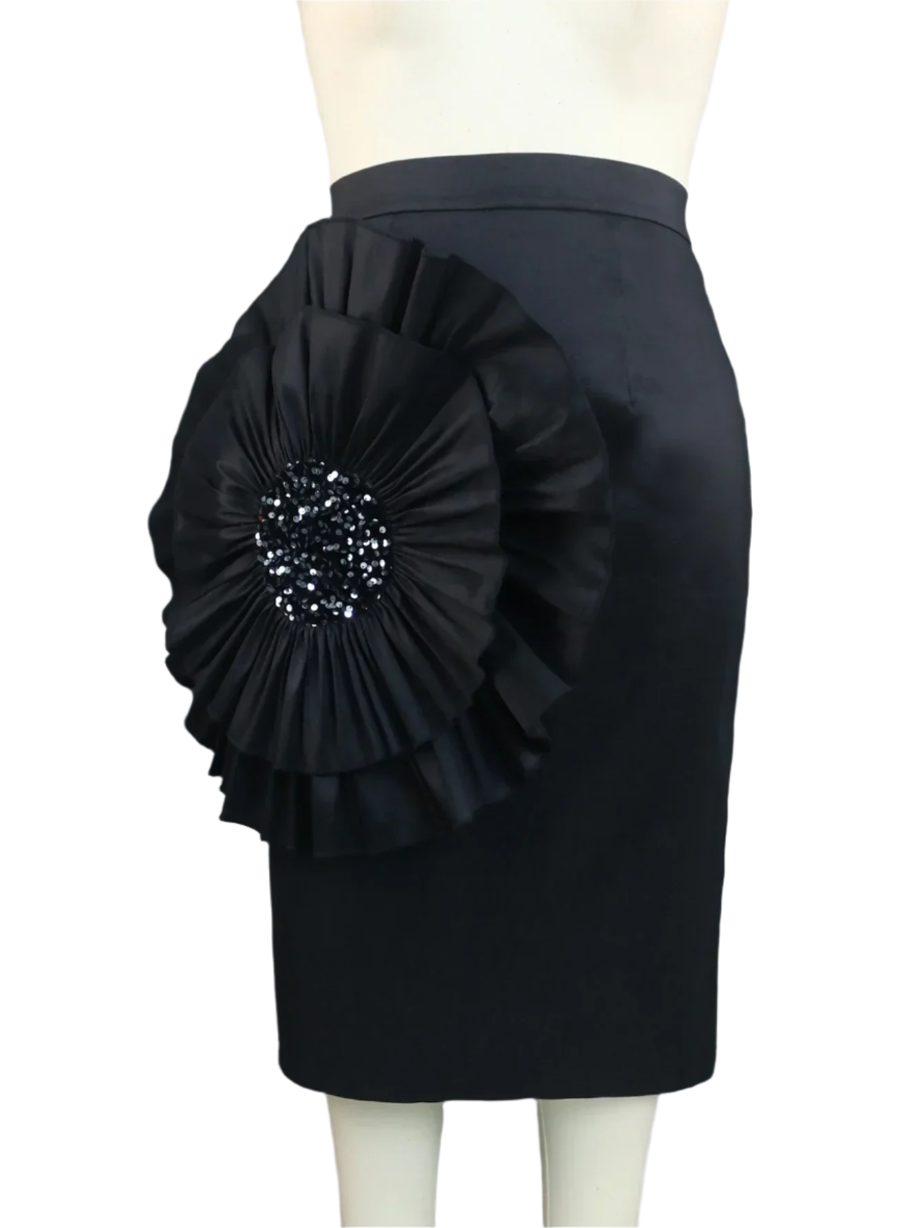 Black pencil skirt with a large floral embellishment on a mannequin against a gray curtain background