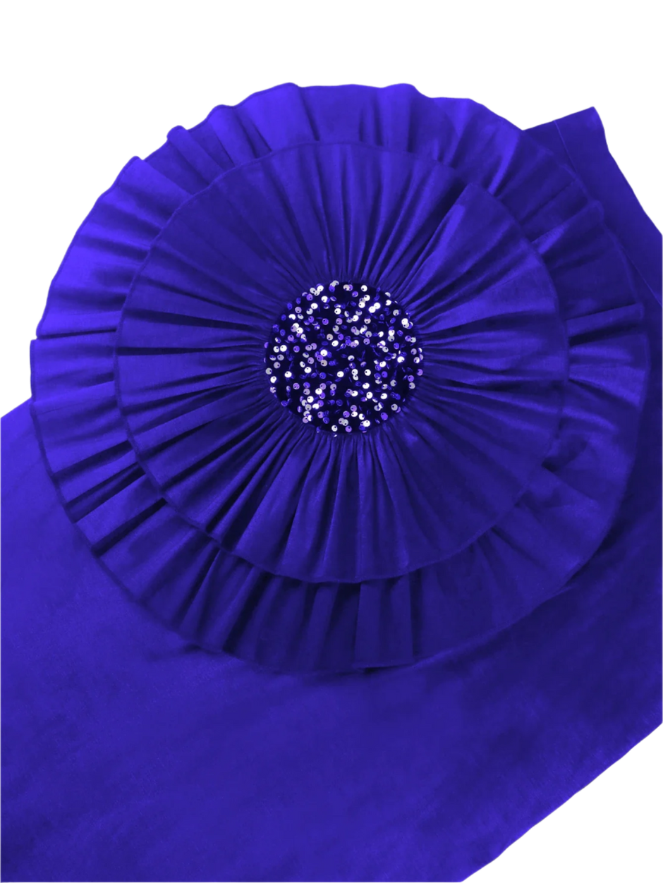 Blue fabric with a pleated design and sequin center on a white background