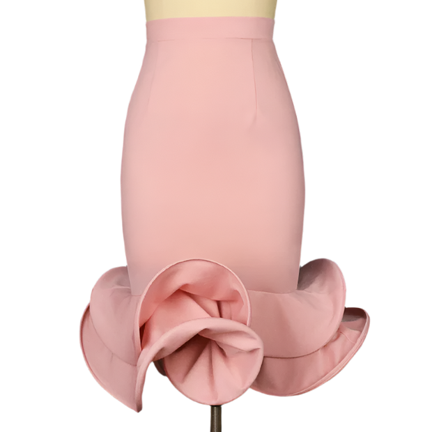 Pink skirt with ruffled bottom on a mannequin against a dark background
