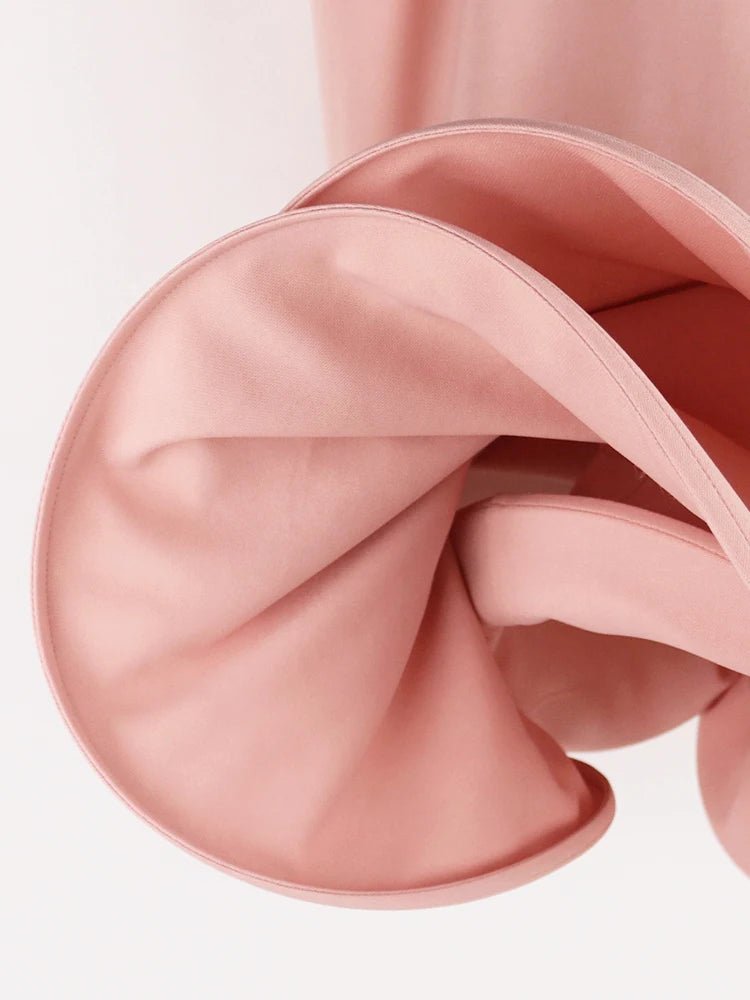 Close-up of pink satin fabric with a white background
