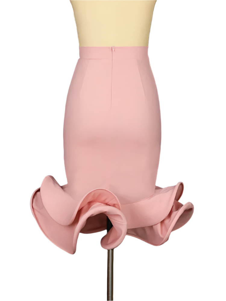 Mannequin wearing a pink ruffled skirt against a dark curtain background