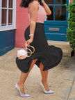 Woman in a black skirt and pink top holding a matching handbag outdoors.
