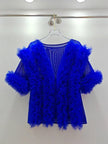 Blue feathered garment on a hanger against a white background