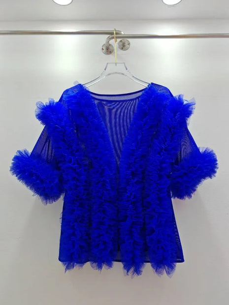 Blue feathered garment on a hanger against a white background