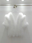 White lace top on a hanger against a white background