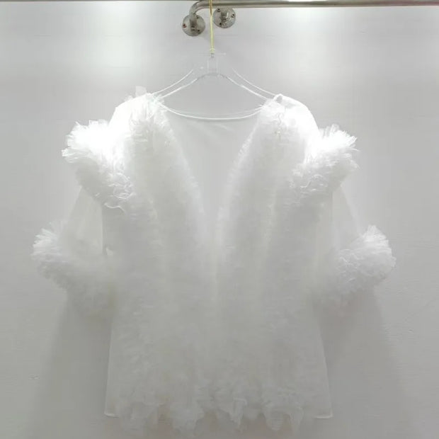 White lace top on a hanger against a white background