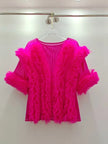 Hot pink feathered top on a hanger against a white background