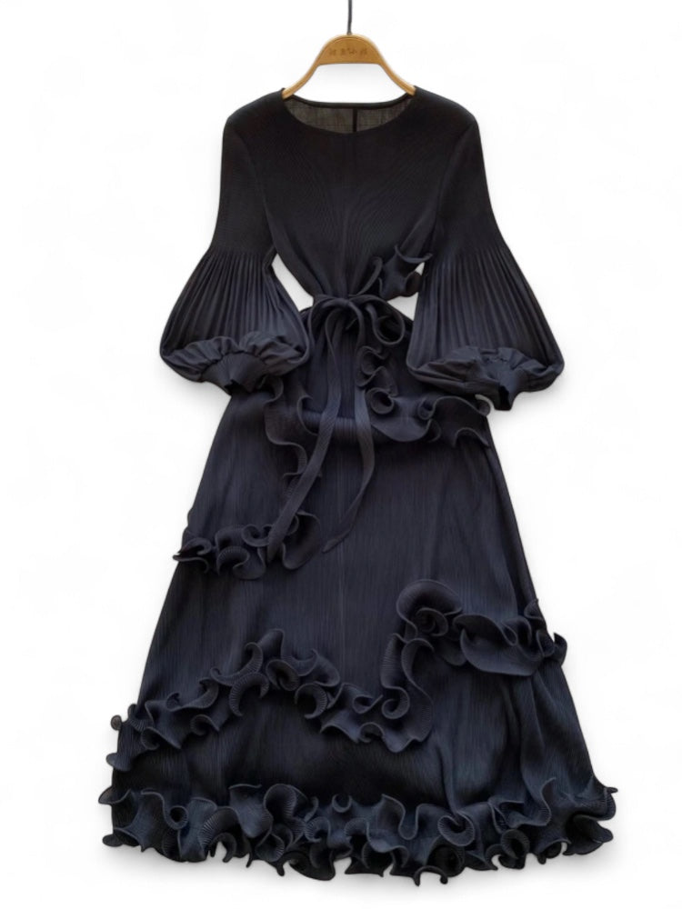 Black ruffled dress on a hanger against a white background