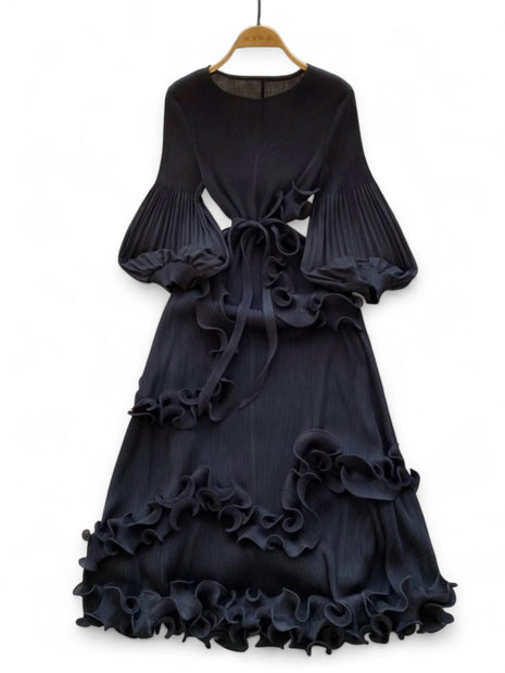 Black ruffled dress on a hanger against a white background