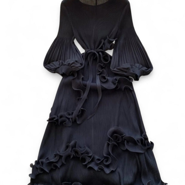 Black ruffled dress on a hanger against a white background