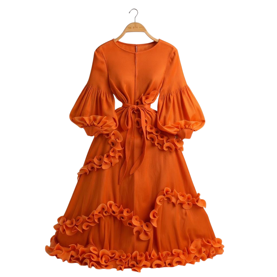 Orange dress with ruffled details on a hanger against a white background