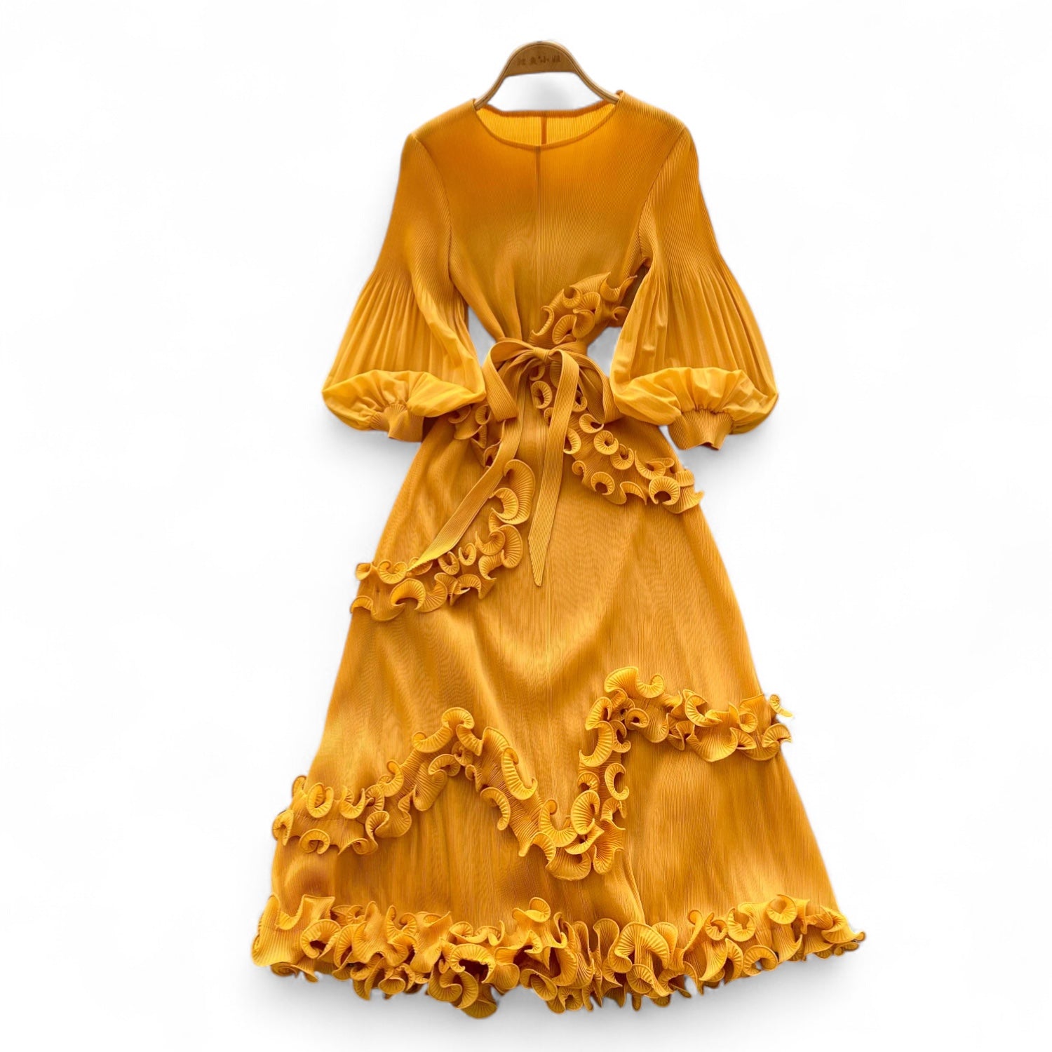 Yellow dress with ruffled details on a white background