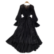 Black pleated dress on a hanger with decorative items on a gray surface