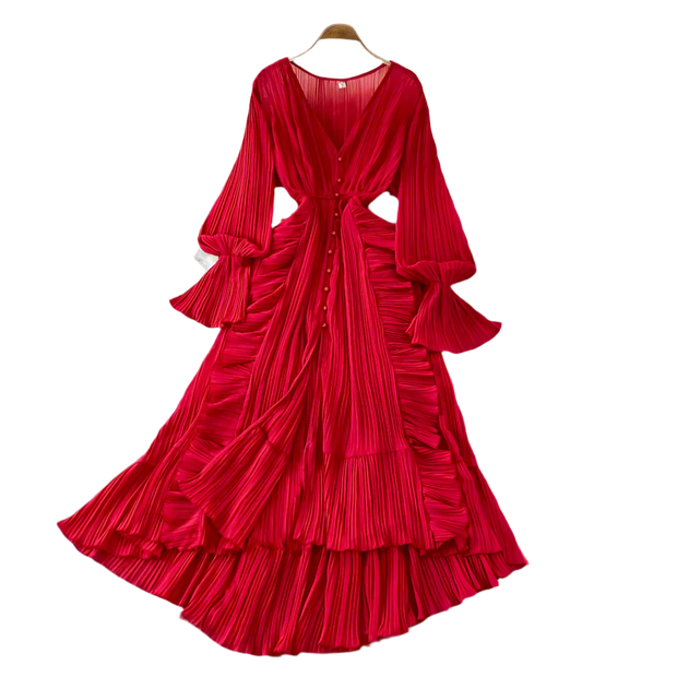 Red pleated dress on a hanger against a neutral background
