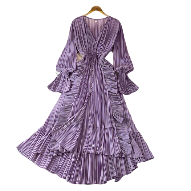 Purple pleated dress on a hanger against a gray background