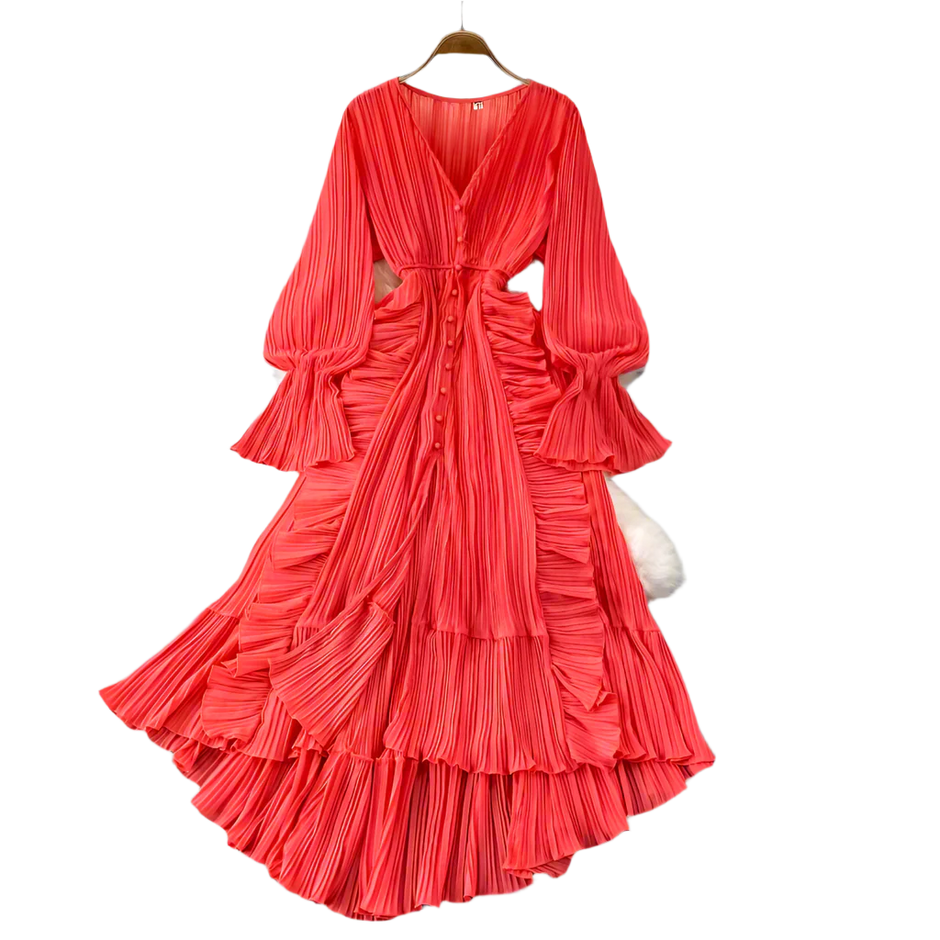Red pleated dress on a hanger against a gray background